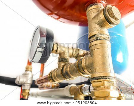 Copper piping system with expansion tanks and pressure gauge in house boiler room