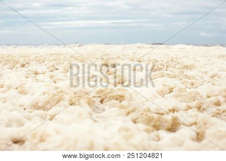 Sea And Skies And A Beach Covered In Sea Foam