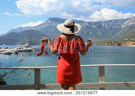 Summer Holidays Relaxing Woman In A Red Dress, Straw Hat Holds In One Hand A Heeled Sandals, In An O