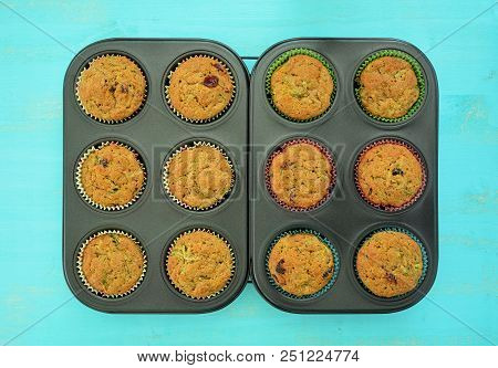 Perfectly Baked Zucchini Cranberry Muffins In Muffin Tins On Rustic Wooden Acqua Surface In Flat Lay