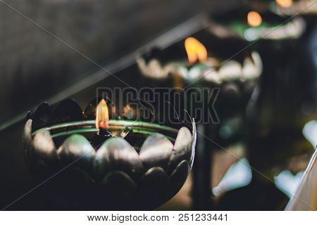 A Row Of Oil Lamp Lighting In Thai Temple