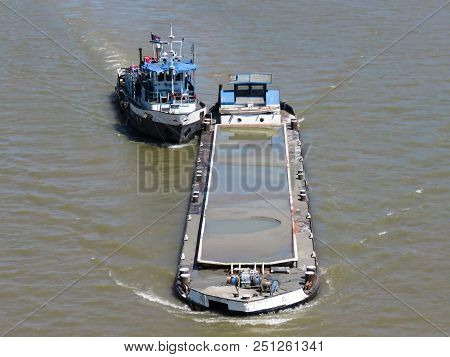 Thug boat maneuvers cargo ship on the Sava river, Belgrade, Serbia.