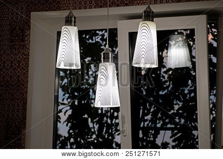 A White Decorative Lamp Hangs From The Ceiling. A Modern Chandelier In The Kitchen.