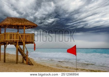 A Red Flag Indicating Dangerous Surf And An Empty Lifeguard Station At The Beach
