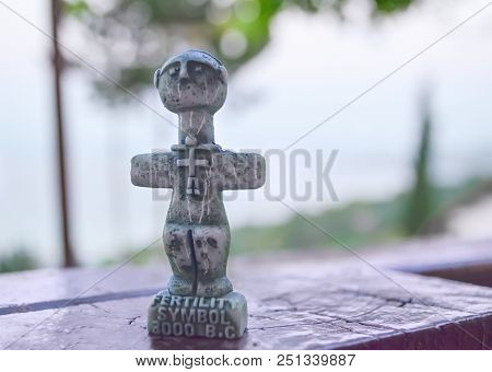 Idol Of Pomos, Ancient Symbol Of Fertility On Cyprus. A Small Sculpture On A Blurred Background. Tra