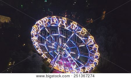 Ferris Wheel In A City Park At Night. Clip. Top View Of The Glowing Ferris Wheel At Night.