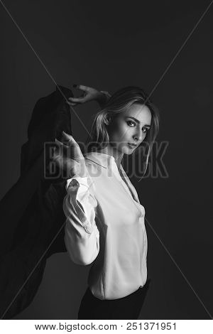 Black And White Portrait Of Blonde Girl In Jacket And White Shirt. Girl Throws A Jacket On Her Shoul