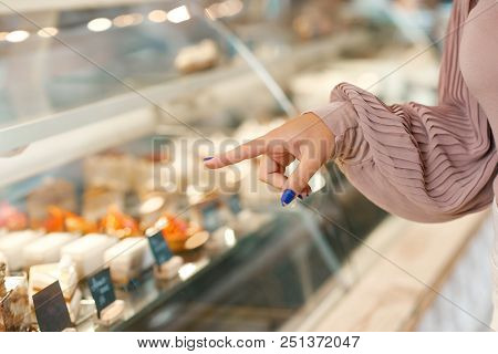 Girl's Hand With Pretty Manicure Gesturing, Choosing Dessert From Showcase.
