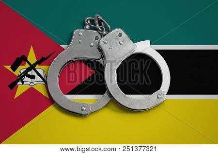 Mozambique Flag  And Police Handcuffs. The Concept Of Observance Of The Law In The Country And Prote