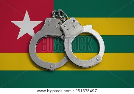 Togo Flag  And Police Handcuffs. The Concept Of Observance Of The Law In The Country And Protection 