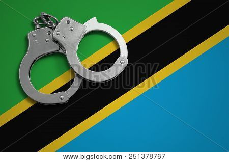 Tanzania Flag  And Police Handcuffs. The Concept Of Crime And Offenses In The Country.