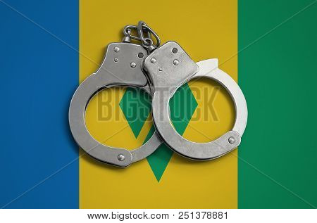 Saint Vincent And The Grenadines Flag  And Police Handcuffs. The Concept Of Observance Of The Law In