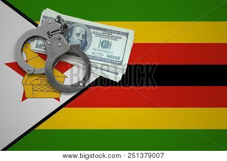 Zimbabwe Flag  With Handcuffs And A Bundle Of Dollars. The Concept Of Breaking The Law And Thieves C