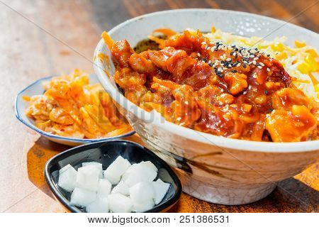 Korean Stir Fried Chicken Rice In White Bowl On Wooden Table