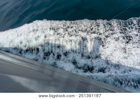 Wave Form And Water Splash Created By Vessel Sail Through The Sea Or Ocean. The Shadow Of The Vessel