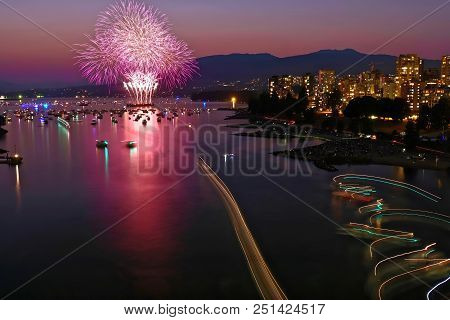 Fireworks In Vancouver. Bc. Annual Festival Of Lights. Fireworks Against The Sunset Sky, Buildings, 