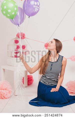 Blonde With Colored Balls On White Background. Studio Portrait Of An Attractive Girl On The Day Of T