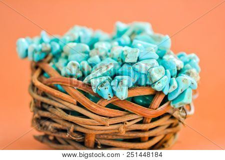 Pile Stones Of Raw Turquoise In Small Wooden Nest On A Brown Background. Blue And Green Color Stones