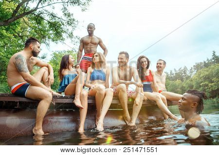 Enjoying Forest Party With Friends. Group Of Beautiful Happy Young Men And Girls Swimming At The Riv