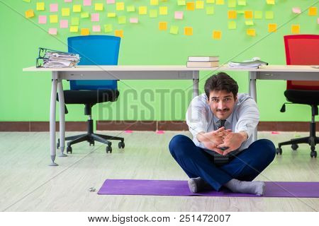 Man in the office with many conflicting priorities doing exercis