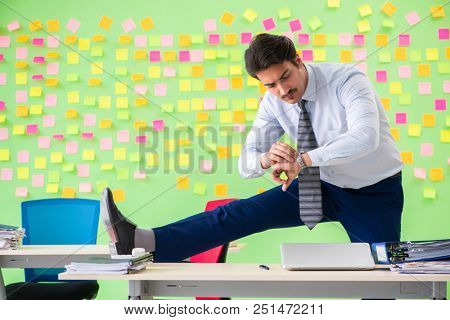 Man in the office with many conflicting priorities doing exercis