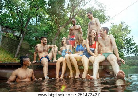 Enjoying Forest Party With Friends. Group Of Beautiful Happy Young Men And Girls Swimming At The Riv
