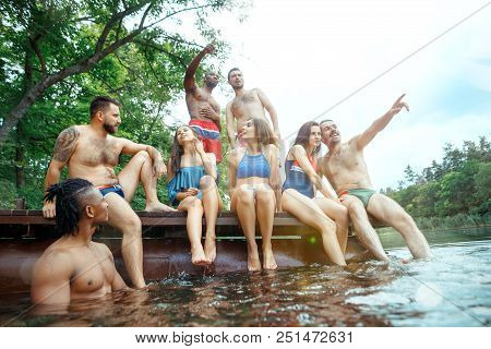 Enjoying Forest Party With Friends. Group Of Beautiful Happy Young Men And Girls Swimming At The Riv