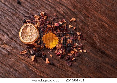 Black Dry Fruit Tea Leaves On Wooden Table. Selective Focus