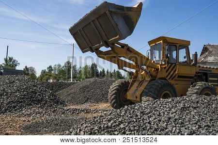 Yellow Loader Moving With Uploaded Bucket To The Truck With Stone Gravel During Road Construction Wo