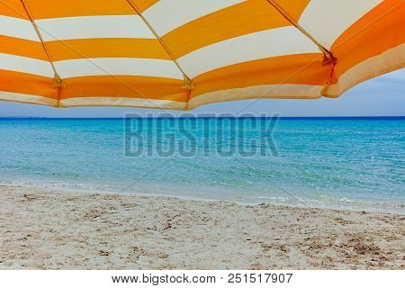 Beach Equipment, Sun Umbrella On White Sandy Beach With Light Blue Sea Water, Beach Vacation Concept