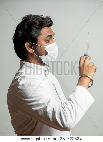 Close Up Side View Sportrait Of Indian Doctor With Syringe Is Preparing For Injection. Pill Bag