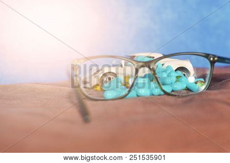 A Baby White Machine Unloads The Blue Capsules And Different Tablets On A Brown Surface Next To The 