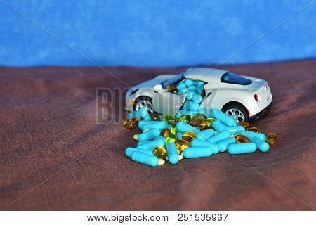 A Baby White Machine Unloads The Blue Capsules And Different Tablets On A Brown Surface Next To The 