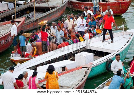 VARANASI, UTTAR PRADESH, INDIA - JULY 6, 2018: Boats with pilgrims arriving at ceremonies Dasashvamedh Ghat 