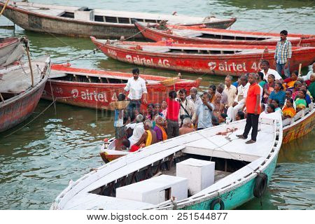 VARANASI, UTTAR PRADESH, INDIA - JULY 6, 2018: Boats with pilgrims arriving at ceremonies Dasashvamedh Ghat 