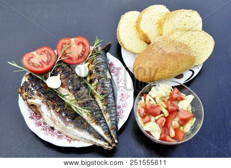 An Apetitic Fish With A Grill Served In A Plate With A Tomato And Onions, A Plate With A Cucumber Sa