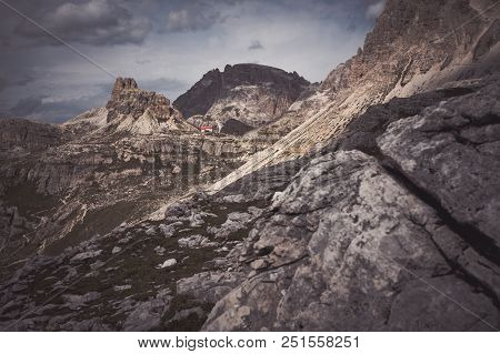 Riffugio In Dolomites Valley, Italy. Rocks In The Front.