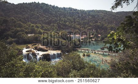Beautiful View Of Plitvice Lakes, Croatia. Tourists Near The Watterfall.