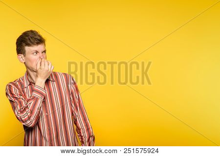 Bad Rancid Foul Smell. Terrible Odour. Man Holding His Breath And Covering Nose. Portrait Of A Guy O