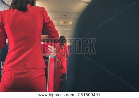 Flight Attendant Serving Food To Passenger On Aircraft. Stewardess Offer Drink On Board. Hostess Wit