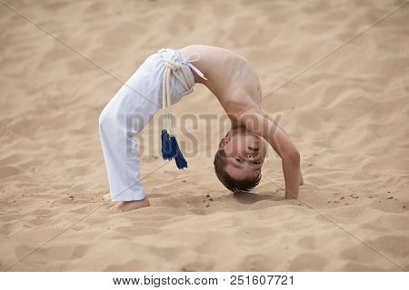 Boy Practicing Capoeira, Brazilian Martial Art That Combines Elements Of Dance, Acrobatics And Music