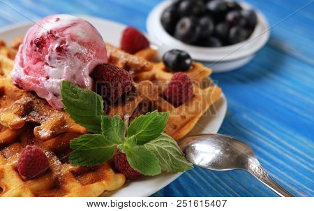 Plate of belgian waffles with ice cream and fresh berries - raspberries and blueberries.top view