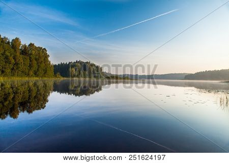 Reflections On The Coniferous Forest On A Wilderness Lake