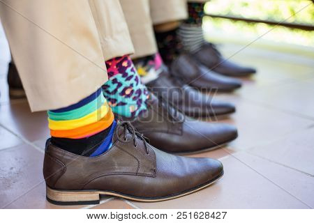 Groomsmen Showing Off Colorful Socks Before Wedding Ceremony