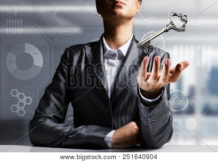 Cropped Image Of Businessman In Suit Keeping Big Key In Hand With Office View On Background.