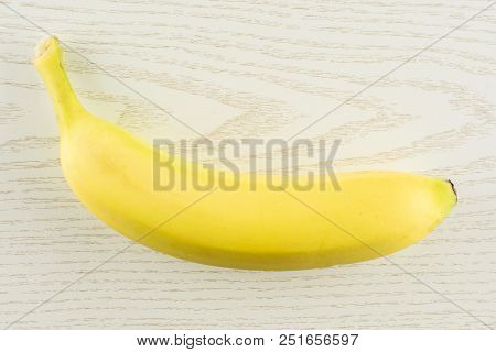 One Whole Fresh Yellow Banana Flatlay On Grey Wood