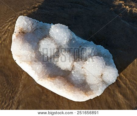 Aurora Rainbow Quartz Cluster From India    On Wet Sand  In Front Of The Lake At Sunrise.
