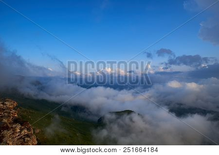 View Of Elbrus Through The Clouds Of The Bermamyt Plateau. Karachay-cherkessia. Russia.