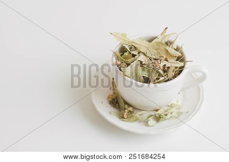 Dried Lime Flowers And Leaves In A White Cup. Herbal Tea