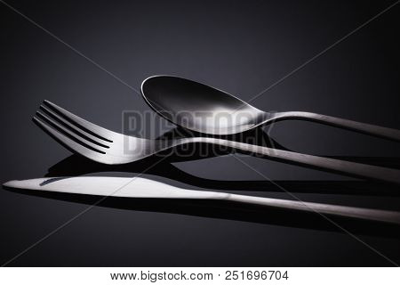 Set Of Stainless Steel Cutlery On A Black Reflective Background, Restaurant Concept